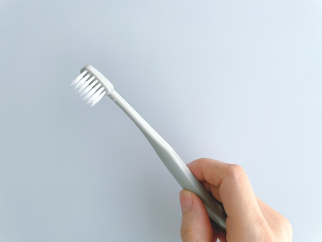 歯ブラシを持つ女性の手
