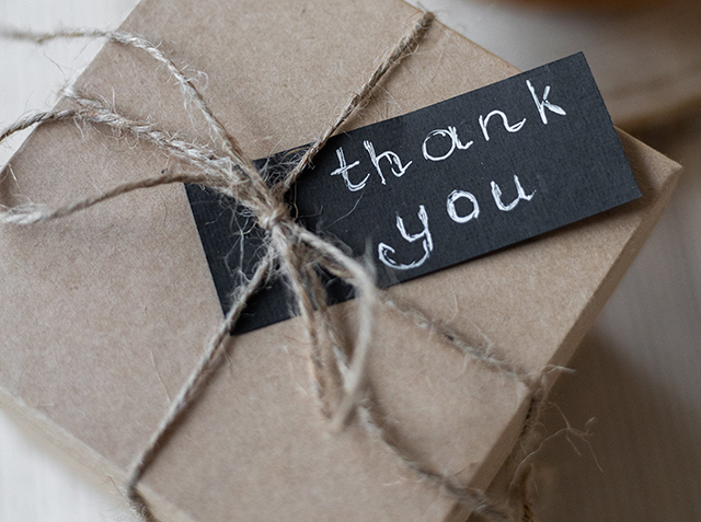 英語で「thank you」と書いてあるメッセージカードが上にのっているプレゼントの箱