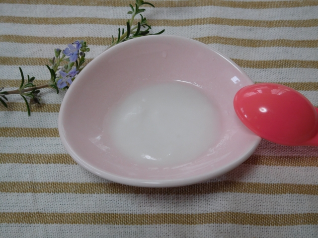 重曹を水でといてペースト状にしたものがお皿の上にある。横にピンクのスプーンもある。
