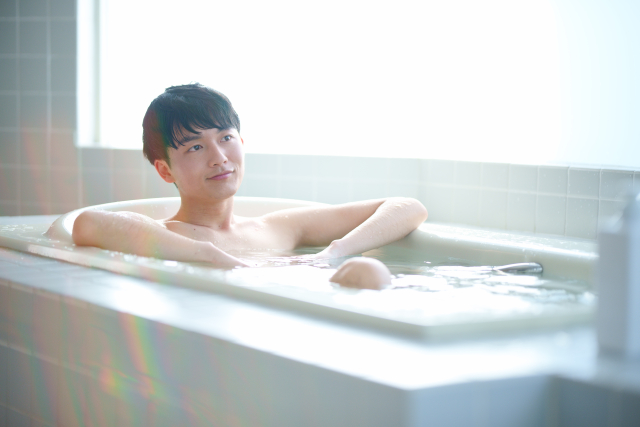 風呂の浸かりリラックスしている若い男性