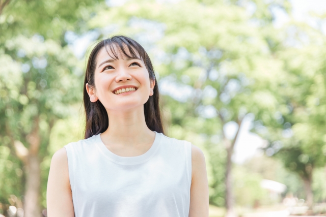 緑の中にいる笑顔の若い女性