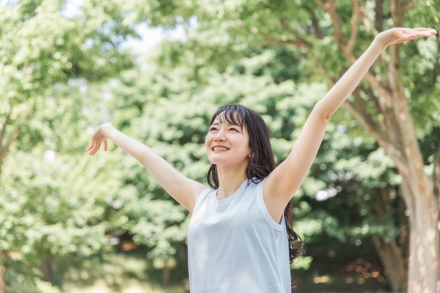 緑の中で深呼吸する若い女性