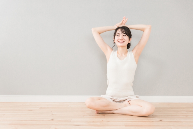 家でストレッチをする若い女性