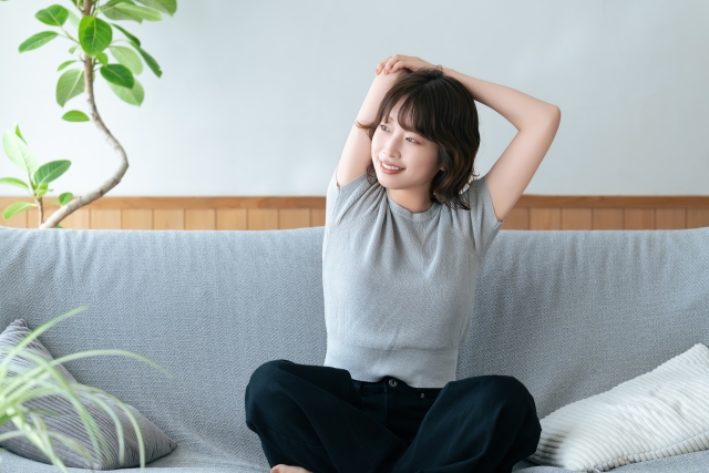 ソファの上でストレッチをする女性