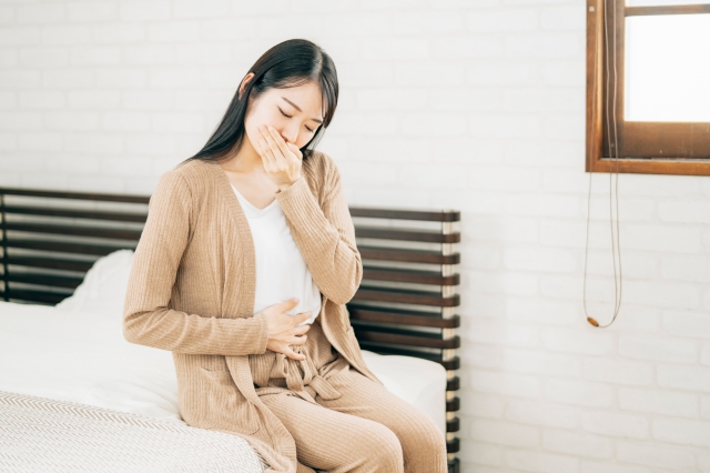 腹痛をおこし、ベッドルームにいる女性