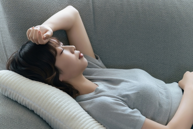 疲れてソファで休む女性