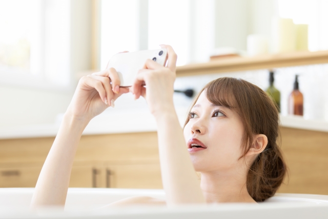 お風呂でスマートフォンを使う女性