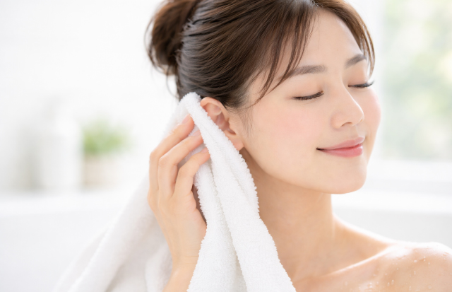 タオルで優しく耳を拭いている若いアジア人女性