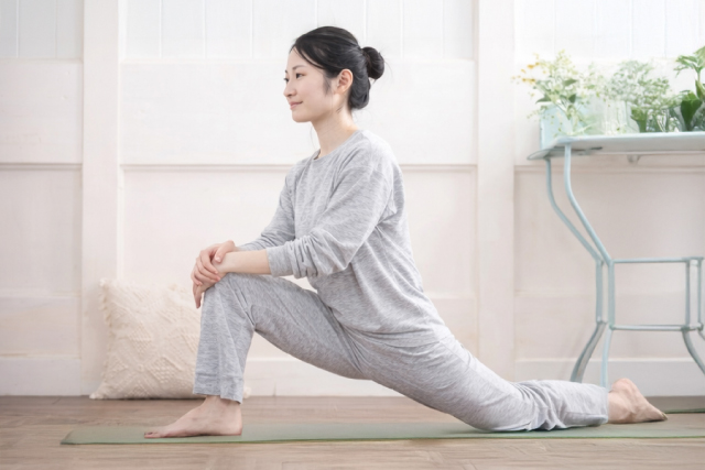 お風呂上りにストレッチをする若い女性