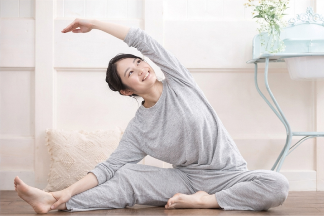 お風呂上りにストレッチをする若い女性