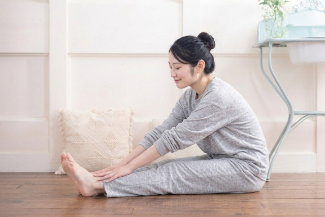 お風呂上りにストレッチをする若い女性