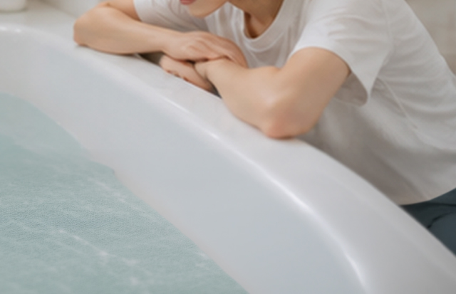 浴槽に手を入れようか迷っている若い女性