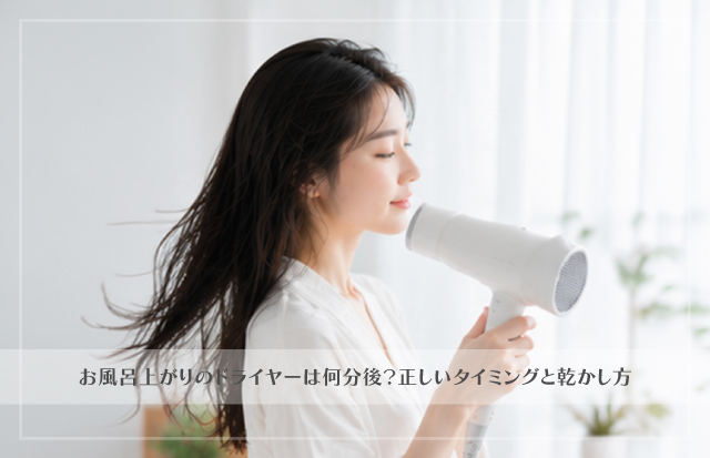 ドライヤーで髪を乾かしている若いアジア人女性