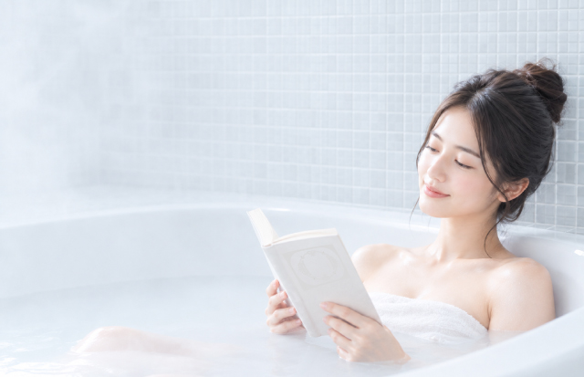 半身浴をしながら読書をする女性