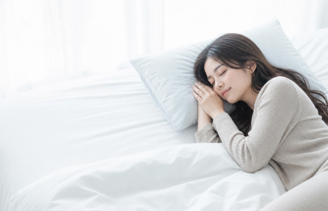 ベッドでぐっすり眠っている若い女性