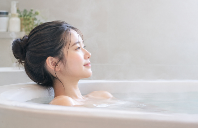 湯舟に浸かりリラックスしている若い女性