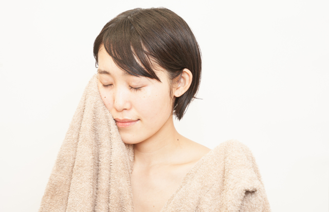 タオルで顔をふく女性